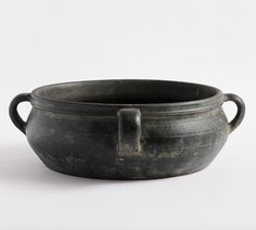 an old black bowl with handles on a white background