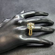 a person's hand with a yellow diamond ring on top of their left hand