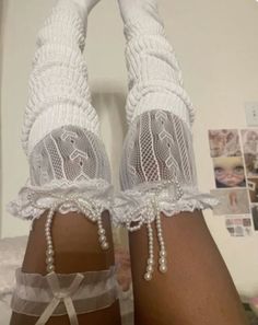 the legs of a woman wearing white socks and garters