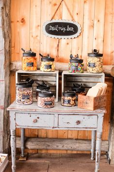 an old wooden table topped with jars filled with food next to a sign that says bread mix bar