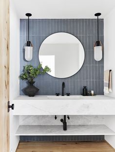 the bathroom is decorated in blue and white tile, with an oval mirror above the sink