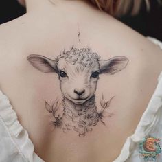 the back of a woman's shoulder with a sheep tattoo on it