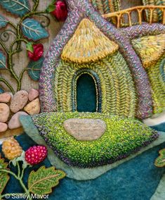 a painting of a house made out of grass and rocks with flowers on the ground next to it