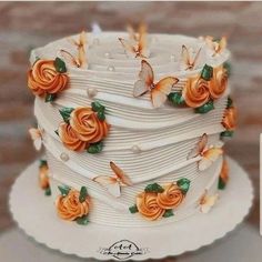 a three tiered white cake with orange flowers on it