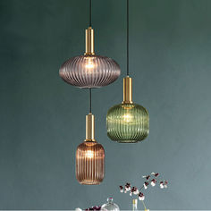 three different colored glass pendant lights hanging from the ceiling