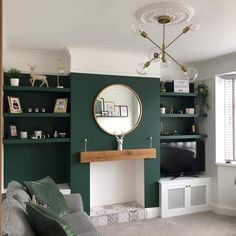 a living room filled with furniture and a fire place in front of a green wall