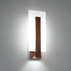 a wall mounted light that is on the side of a wall in a room with white walls