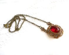 Beautiful victorian style pendant necklace made of a lovely oxidized brass filigree cabochon base, American made, and a vintage ruby red rhinestone cabochon. The size of the cabochon is 13 x 18 mm. The necklength is approximately 49 cm. (19.3 inches) For more jewelry please visit our shop: http://www.minouc.etsy.com For combined shipping please contact us. We also combine shipping with our other Etsy shop where we sell vintage fabrics and finds from Holland and France: http://www.minoucbrocante. Victorian Pendant Necklace, Red Pendant Necklace, Victorian Filigree, Red Pendant, Purple Wrap, Victorian Pendants, Brass Filigree, Filigree Necklaces, Red Pendants