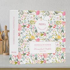 a mother's day card with flowers and leaves on it next to two wooden pegs