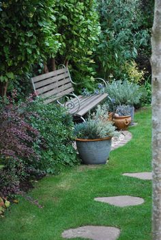 a wooden bench sitting in the middle of a garden