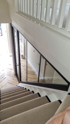 a man is walking down the stairs in front of a mirror