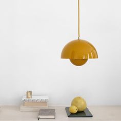 a yellow light hanging over a table with books and other items on top of it