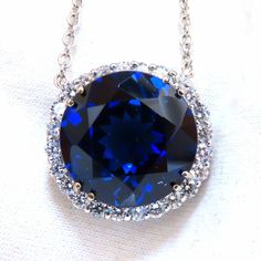 20.09ct. Lab Created Sapphire Pendant Royal Blue Color Clean Clarity & Transparent Brilliant Round Cut Diameter 16.9mm 1.50ct. Natural Round Diamonds. Full Cut, Brilliant Vs-2 Clarity G-Color. Overall Measurement: Pendant: 21mm Diameter All Of 14kt. White Gold. Grand Weight: 12 Grams Appraisal Will Accompany For: $9,000 Formal Royal Blue Round Jewelry, Formal Blue Jewelry With Brilliant Cut, Formal Blue Necklace With Halo Setting, Formal Blue Necklaces With Halo Setting, Royal Blue Round Jewelry With Brilliant Cut, Royal Blue Round Brilliant Cut Jewelry, Blue Sapphire Diamond Pendant, Royal Blue Sapphire Ring, Sugar Skull Necklace