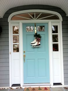 a blue front door with snow boots and wreath on it