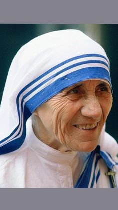 an older woman wearing a blue and white headdress with a cross on it