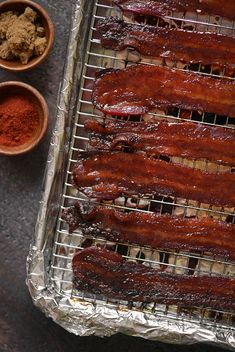 bacon is cooking on the grill and ready to be cooked with other ingredients around it