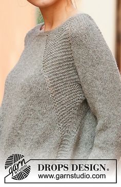 a woman wearing a gray sweater and smiling at the camera