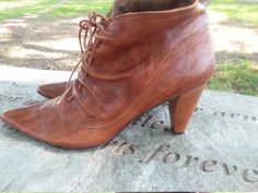 a pair of brown shoes sitting on top of a stone