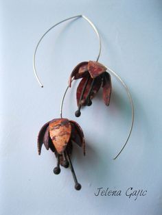 two earrings made out of metal and wood