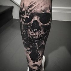 a man's leg with a black and grey tattoo on it