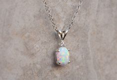 "Gorgeous pairing of a white opal and CZ accent gemstone. The gemstones are handset into a sterling silver pendant and hung from a sterling silver chain. This white opal has amazing flashes of color when it catches the light. The resulting necklace is stunning yet simple, a truly elegant necklace! The necklace ships in a lovely gift box ready to give as a gift or keep for yourself! Pictured with cubic zirconia accent stone color: \"White / Clear - April\" Setting Material - 925 Sterling Silver C Elegant Silver Jewelry With Pink Opal, Elegant Silver Pink Opal Necklaces, Elegant Silver Pink Opal Necklace, Elegant Silver Pink Opal Jewelry, White Opal Pendant Jewelry, Silver Opal Birthstone Jewelry, White Sterling Silver Birthstone Necklace, White Gold Opal Necklace For Gift, White Gold Opal Necklace As Gift