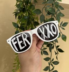 a person holding up their sunglasses with the word fer on it in black and white