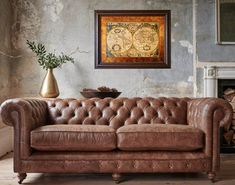 a brown leather couch sitting in front of a fire place