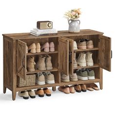 a wooden cabinet filled with shoes next to a vase full of flowers on top of a table