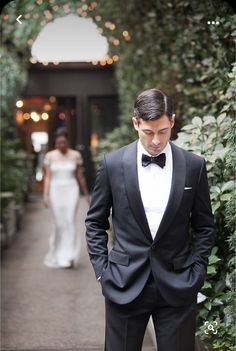 a man in a tuxedo standing next to a woman