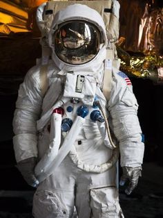 an astronaut is standing in the dark with his hands on his hips and wearing a space suit