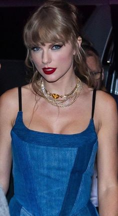 taylor swift is wearing a blue dress and red lipstick