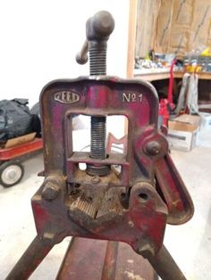 an old bench vice sitting on top of a wooden table