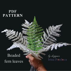 a person holding a fake fern leaf in their hand with the caption'pf pattern beaded fern leaves '