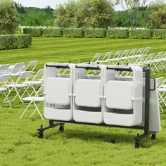 there are many white chairs in the grass