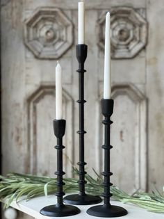 two candles sitting on top of a white table