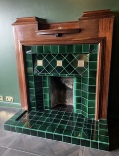 an old fireplace with green tiles and wood