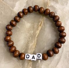 Dad Bracelet - the gift he never knew he needed  Made with wooden beads or 3mm seed beads. Wooden beads are positive intentions beads and have lava rock energy 🌋🌋they are giving all the positive vibes 🌊 Customize bracelet with personalized word or saying and bead colors. See color chart in photos. We have circle and square letters.  CARING TIPS FOR YOUR JEWELRY ⭐️Treat and store with care. ⭐️ For longevity, avoid exposing your jewelry to water. ⭐️ Avoid having direct contact with lotions, per Customize Bracelet, Square Letters, Dad Bracelet, Positive Intentions, Customised Bracelets, Stretchy Beaded Bracelet, Word Bracelet, Lava Rock, Gifts For Father