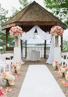 an image of a wedding ceremony with flowers on the aisle and white draping