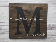 a wooden sign with the letter m on it