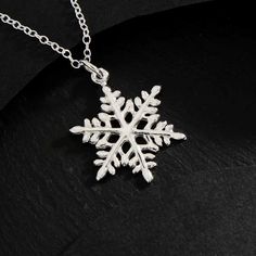 Sterling Silver Snowflake Charm Necklace NA1056 -SV-NECK This sterling silver snowflake charm necklace reminds us of the beauty of falling snow, a magical event binding heaven and earth. Tiny ice crystals fall from the sky as snowflakes form around a nucleus of earth-born dust. The geometric perfection of snowflakes has won it many admirers.  As if by some cosmic decree, every snowflake has six sides. Because the number six is associated with affection, the snowflake was used by Pagans as a symbol of love. Stock up on snowflake necklaces as the air chills and Christmas approaches. Perfect gift for winter birthdays, and Holiday parties. Comes on a simple 16, 18, 20, 22 inch cable chain with spring ring clasp.  Measurement (mm): Length: 18 Width : 16  Height: 1 - Snowflake Snow Necklace, Necklace Snowflake, Snowflake Jewelry, Crystal Falls, Number Six, Falling Snow, Snowflake Necklace, Stained Glass Jewelry, Heaven And Earth