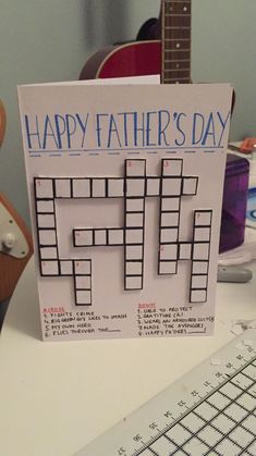 a father's day card sitting on top of a desk next to a guitar