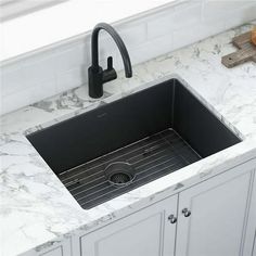 a black kitchen sink sitting under a faucet