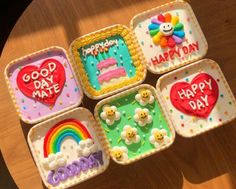 four small trays with happy birthday cakes on them sitting on top of a table