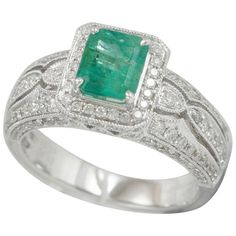 This spectacular ring from the Suzy Levian Limited Edition collection features a Colombian emerald gemstone held in a square shaped 14K white gold prong setting. An array of 138 side white diamonds (.83ct) with hand-carver French filigree work across the band, accents the perfect white gold color of the square cut center stone emerald (0.99ct) The brilliance of these gems and the luster of the high-polish finish of the white gold creates an eye catching piece of jewelry. Side Stone: Diamond Diam Emerald Band, Emerald And Diamond Ring, Emerald Diamond Ring, Colombian Emeralds, 14k White Gold Ring, Emerald Gemstone, Jewelry Rings Engagement, Cocktail Rings, Emerald Cut