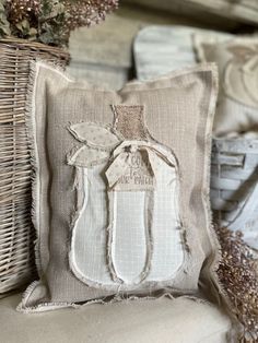 a decorative pillow with an angel on it and some dried flowers in the basket next to it