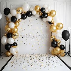 black and gold balloon arch with confetti