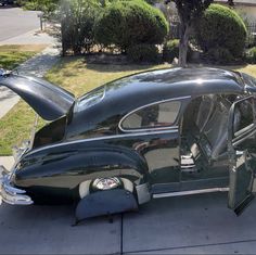 an old car is parked on the sidewalk