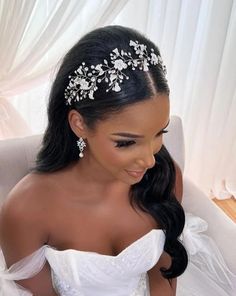 a woman sitting in a chair wearing a wedding dress with flowers on the headband