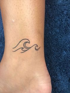 a foot with a wave tattoo on it