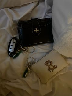 a purse and keychain laying on a bed